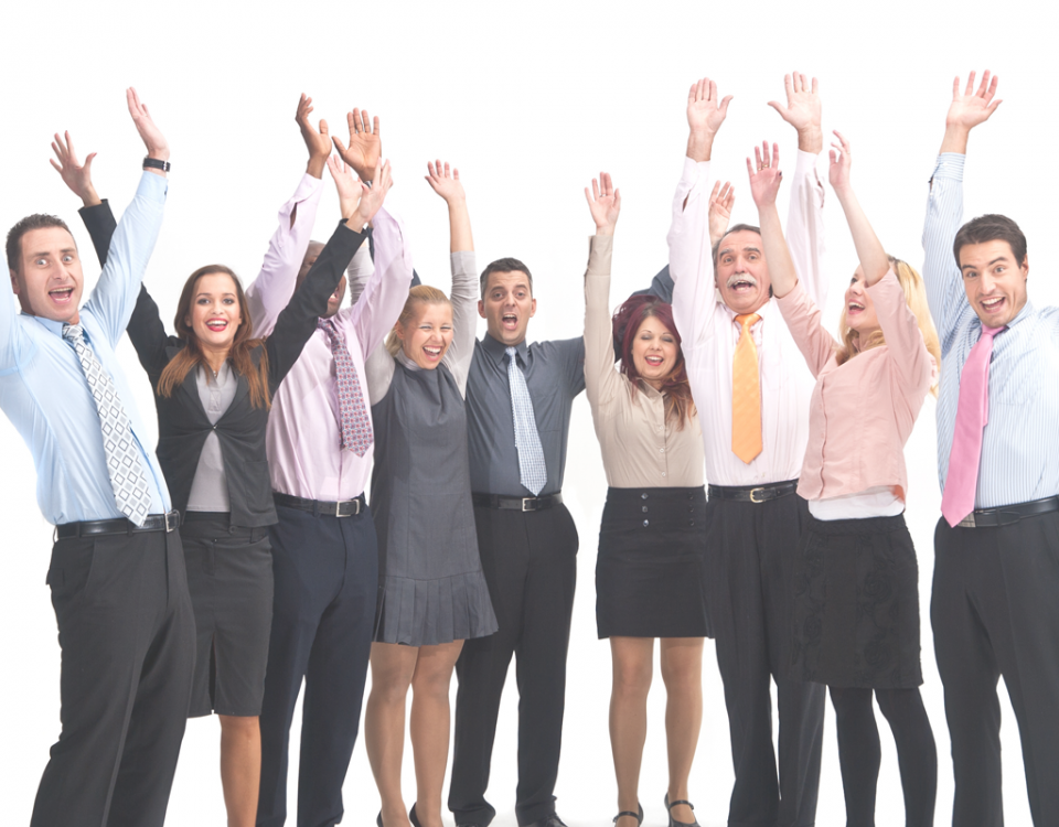 9 Personen im Business-Outfit strecken die Hände in die Luft und jubeln