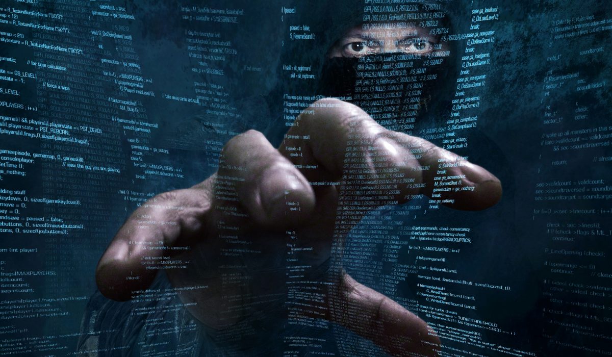 Hand eines Hackers vor einem Bildschirm