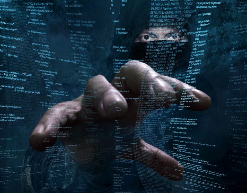Hand eines Hackers vor einem Bildschirm